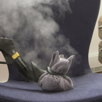 Duplex steam cleaner is cleaning the upholstery.