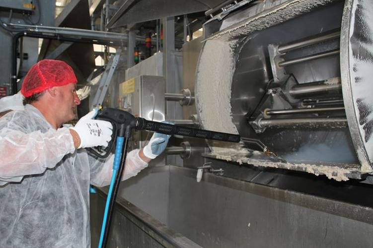Image displaying the meticulous cleaning of food processors in a food and beverage manufacturing facility with specialised equipment.