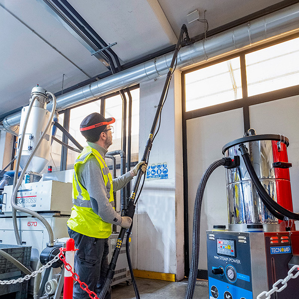 Image of a warehouse ceiling being cleaned using the Tess High Ceiling Vacuum Cleaner with steam pressure.