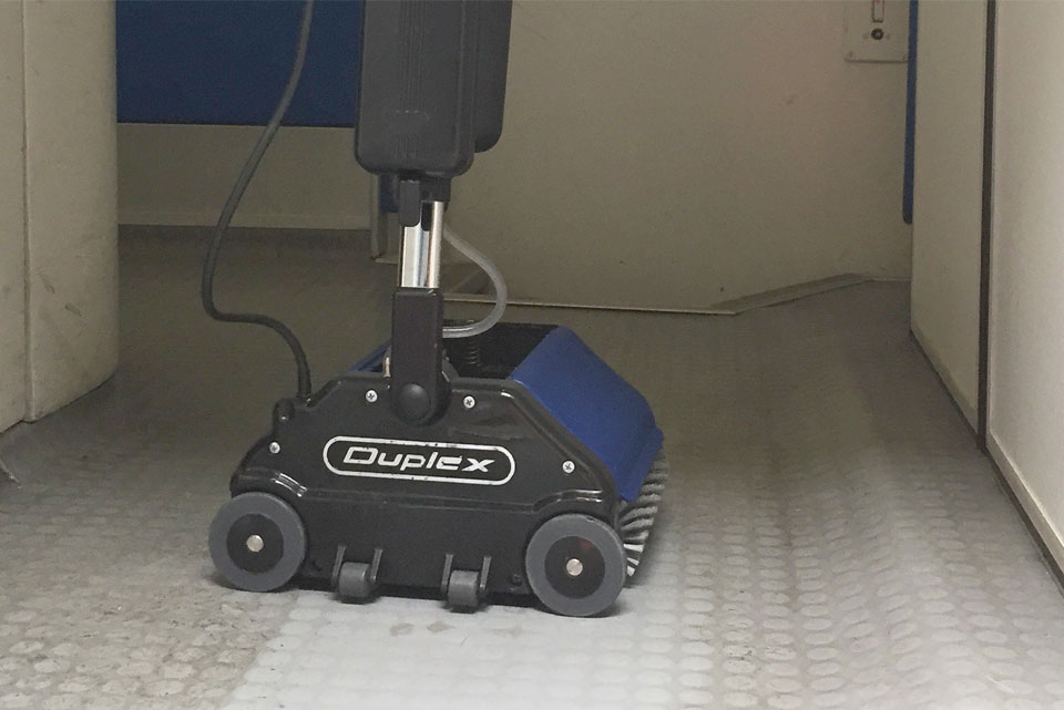 Duplex Lithium Cordless Floor Cleaner washing, scrubbing, and drying a floor surface in one pass.