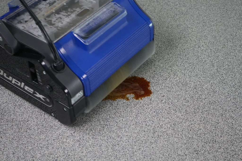 Duplex floor cleaner removing a stain from a hard surface.