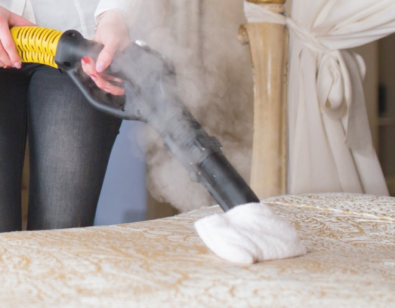 Steam cleaning a mattress in a retirement village to remove odours and sanitise without chemicals.