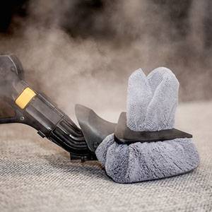 Steam cleaning upholstery with a cloth attachment, ideal for various surfaces like tiles and carpets.