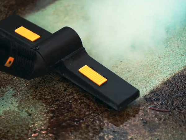 Close up of a commercial steam cleaner removing grime with high-temperature dry steam.